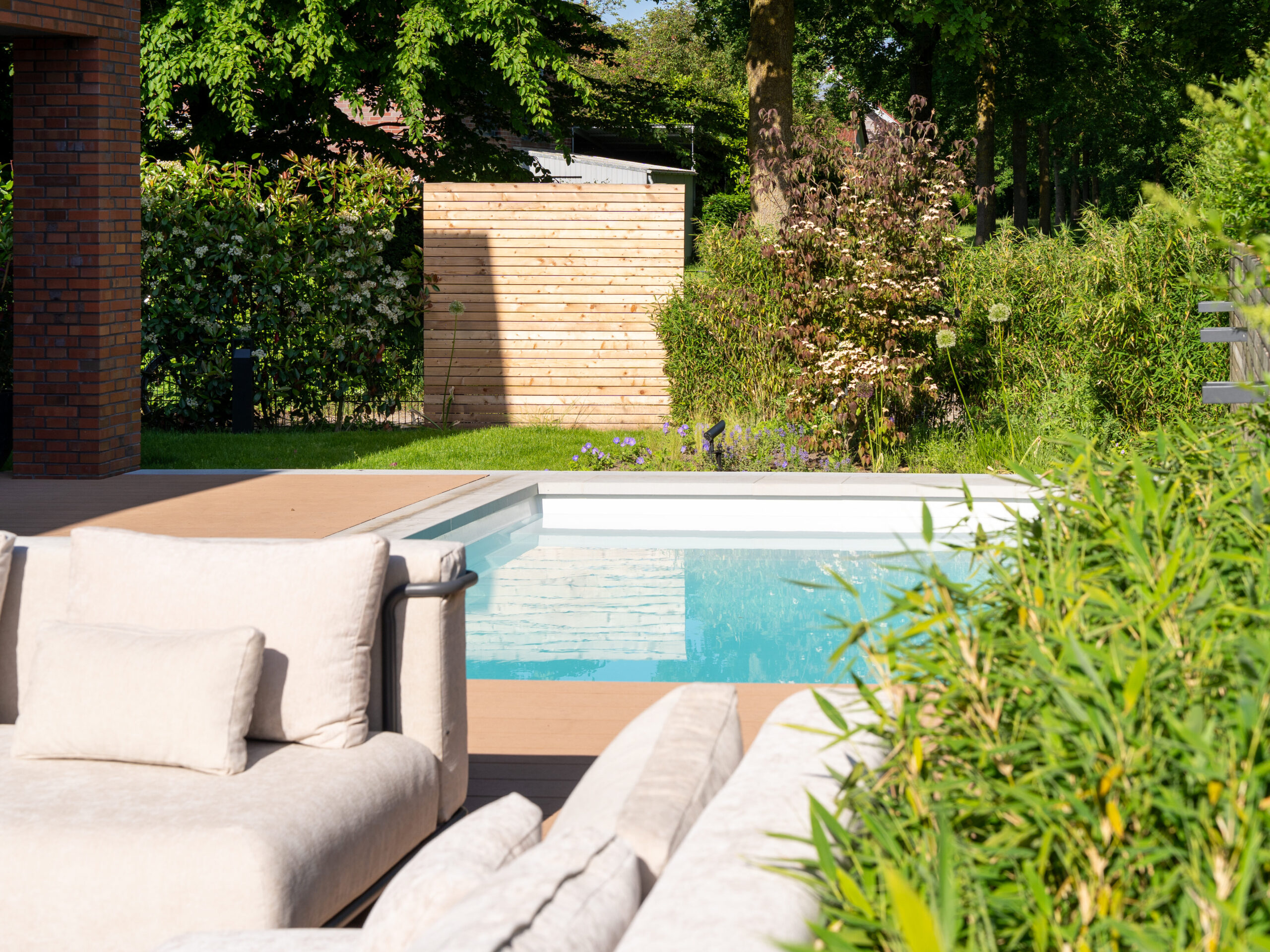 Pool und Terrasse eingebettet in einen grünen Garten